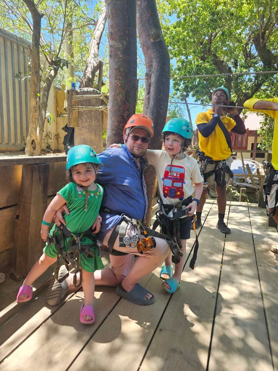 Father and children with helmets ready for the Roatán zipline