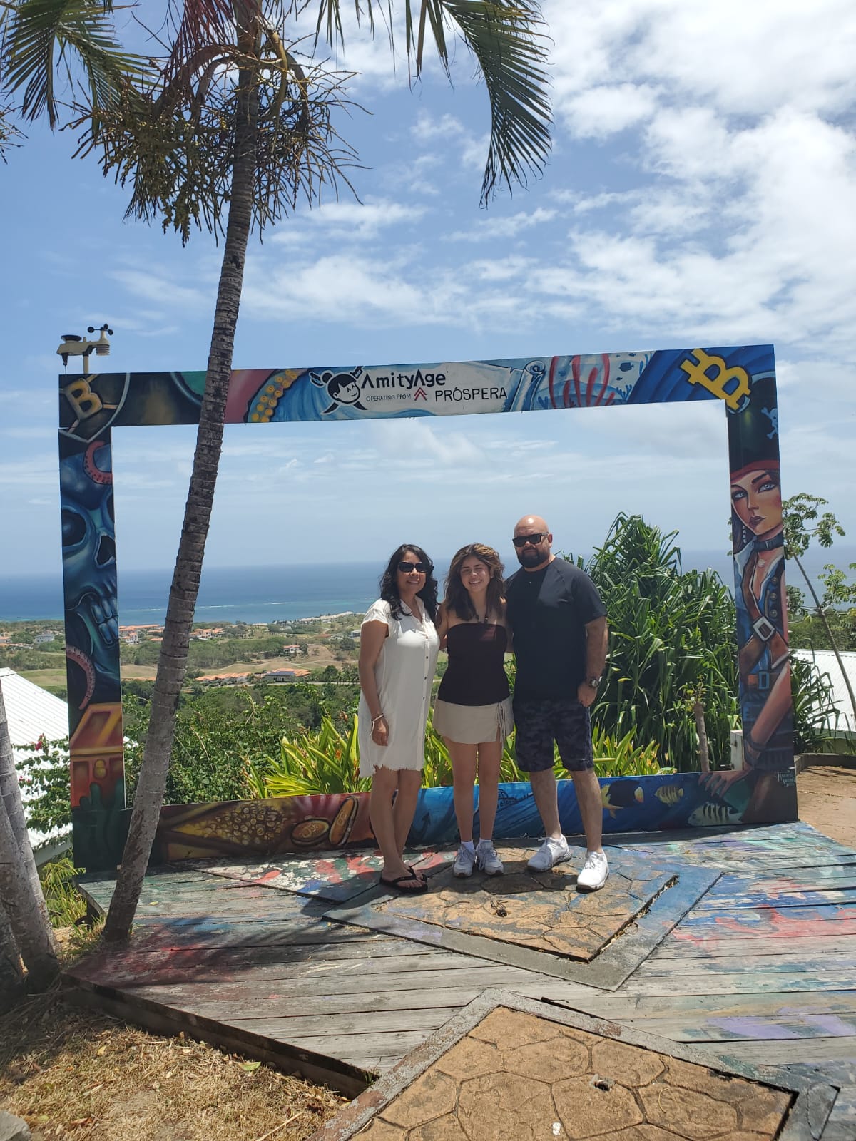 Family posing in the painted photo frame at a Roatán hilltop viewpoint